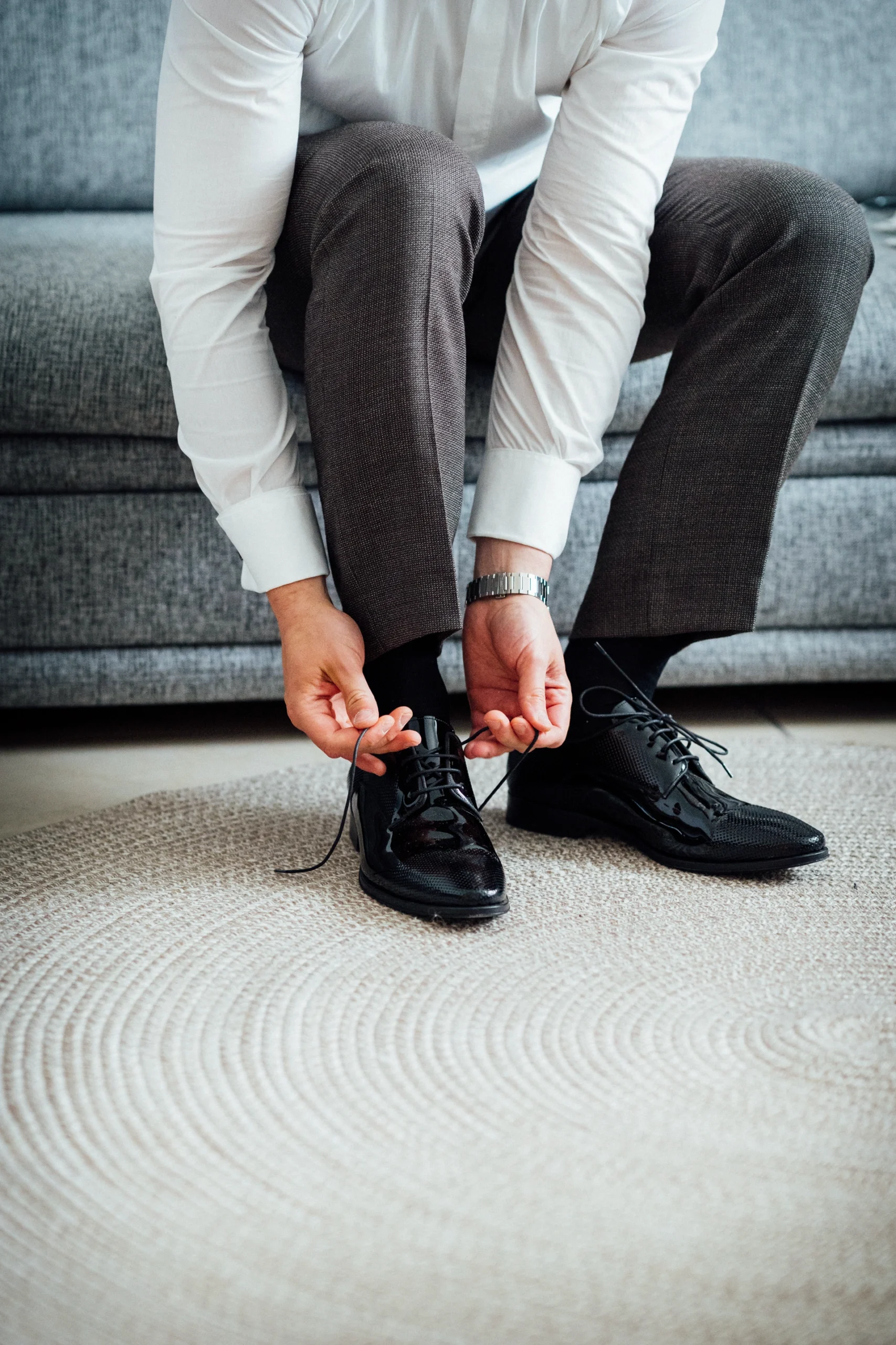 Der Bräutigam zieht sich im Haus der Eltern seine Schuhe an