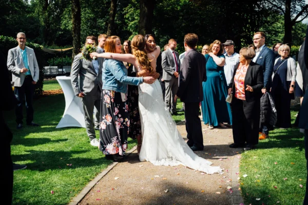 Die Braut umarmt ihre Gäste nach einer freien Trauung im Garten von Bökamp in Rietberg