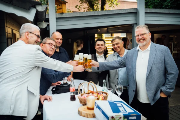 Gäste einer freien Trauung prosten sich mit einem Glas Bier zu