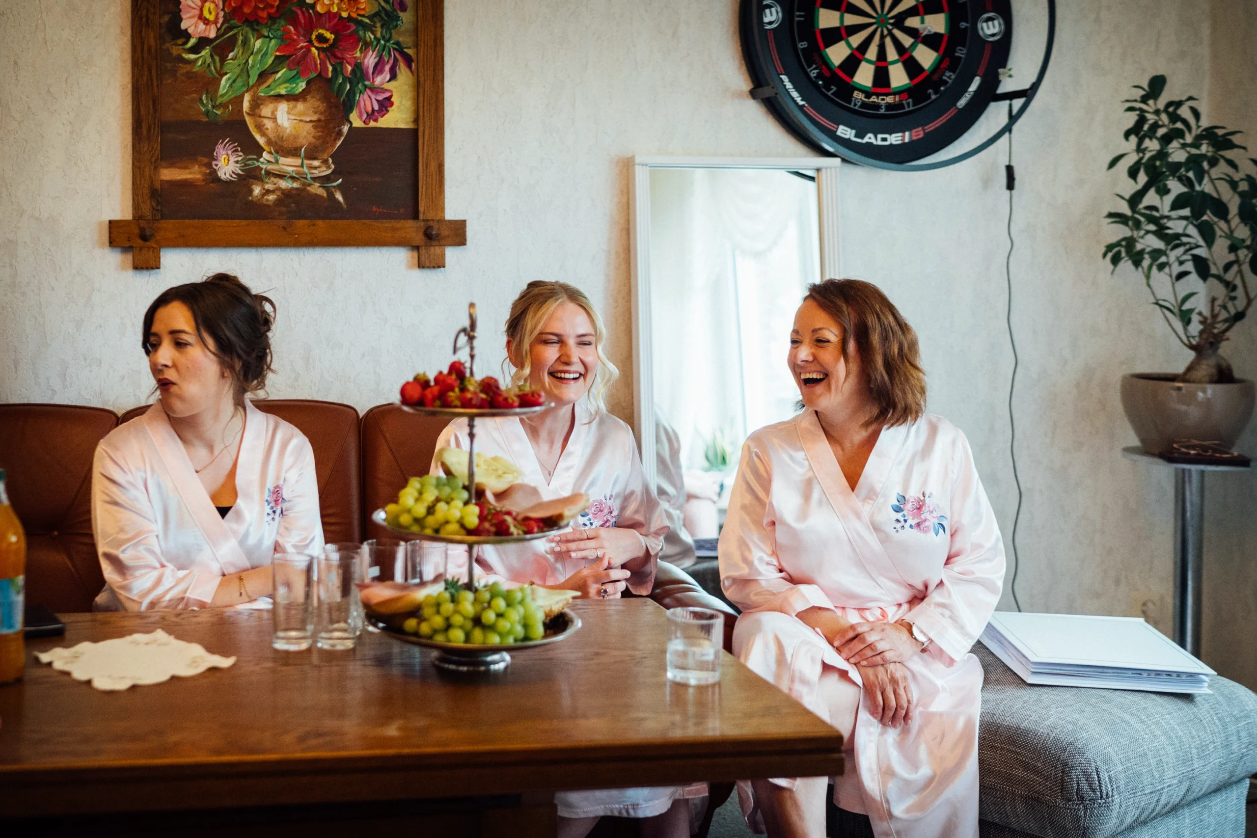 Brautmutter mit Brautjungfern sitzend lachend auf einem Sofa