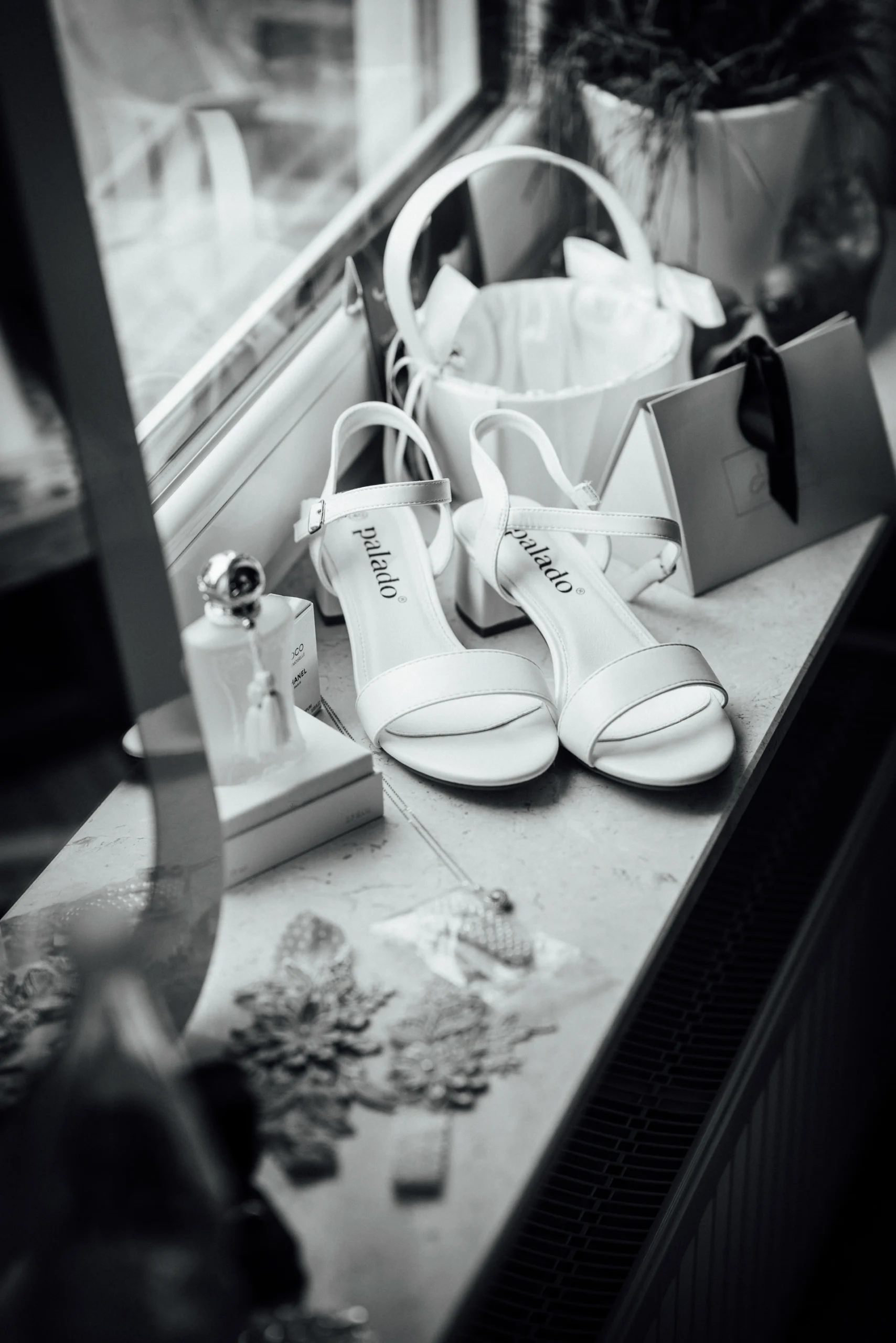 Brautschuhe und weitere Accessoires stehen auf einer Fensterbank