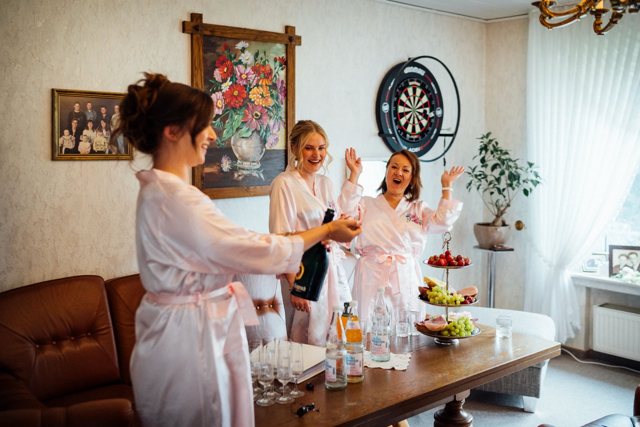 Eine Brautjungfer öffnet beim Getting Ready eine Flasche Sekt