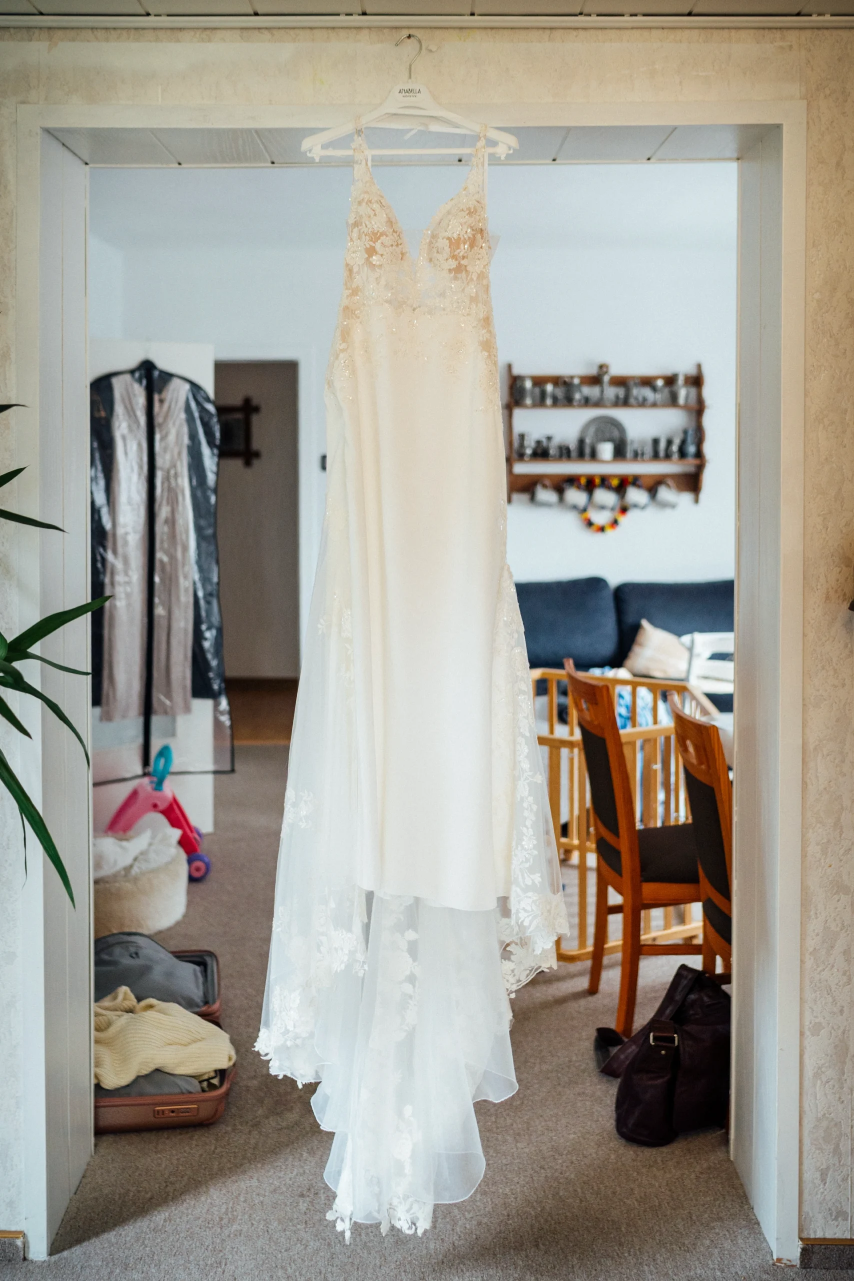 Ein Brautkleid hängt beim Getting Ready an einem Türrahmen