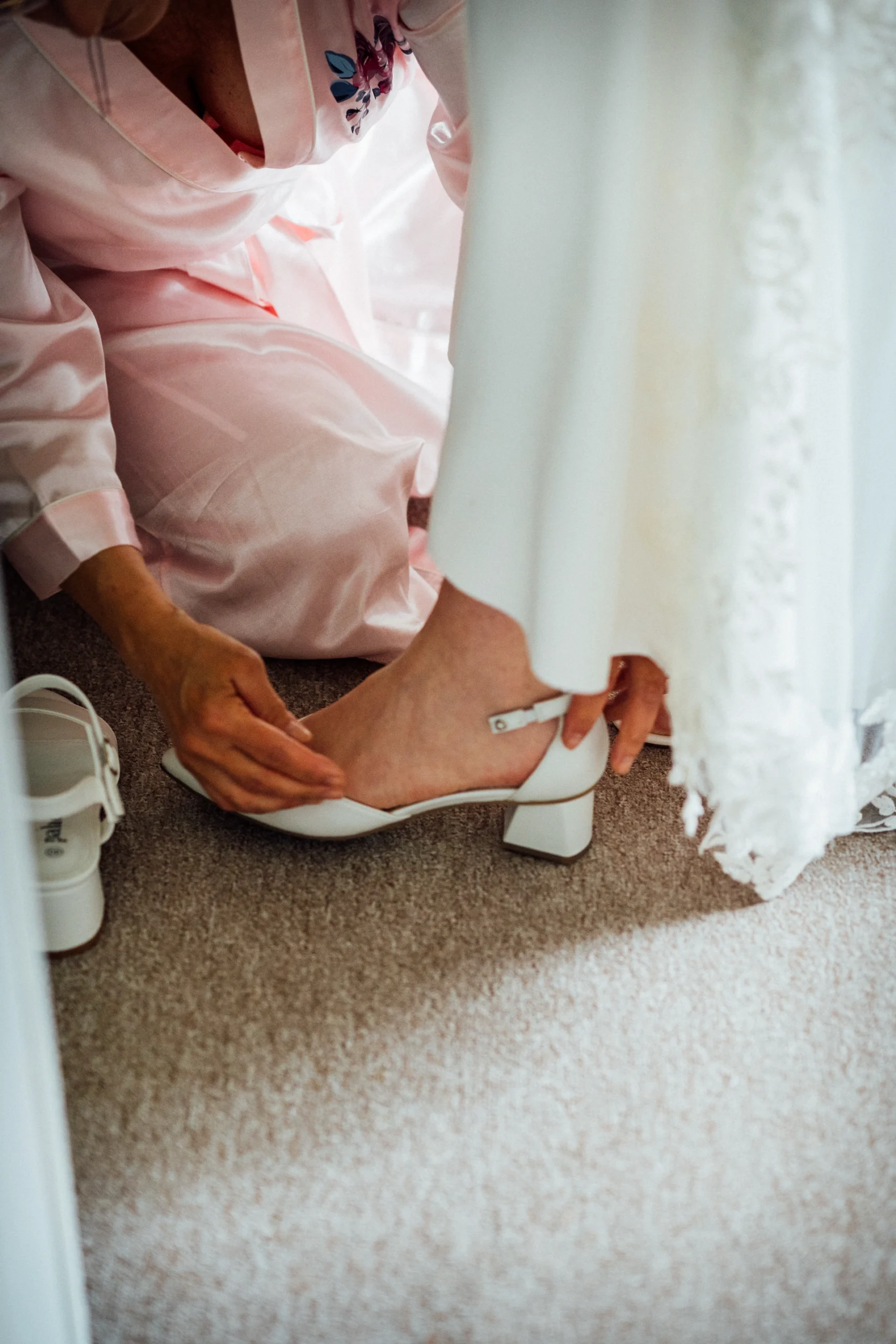 Die Mutter der Braut hilft beim Anziehen der Brautschuhe