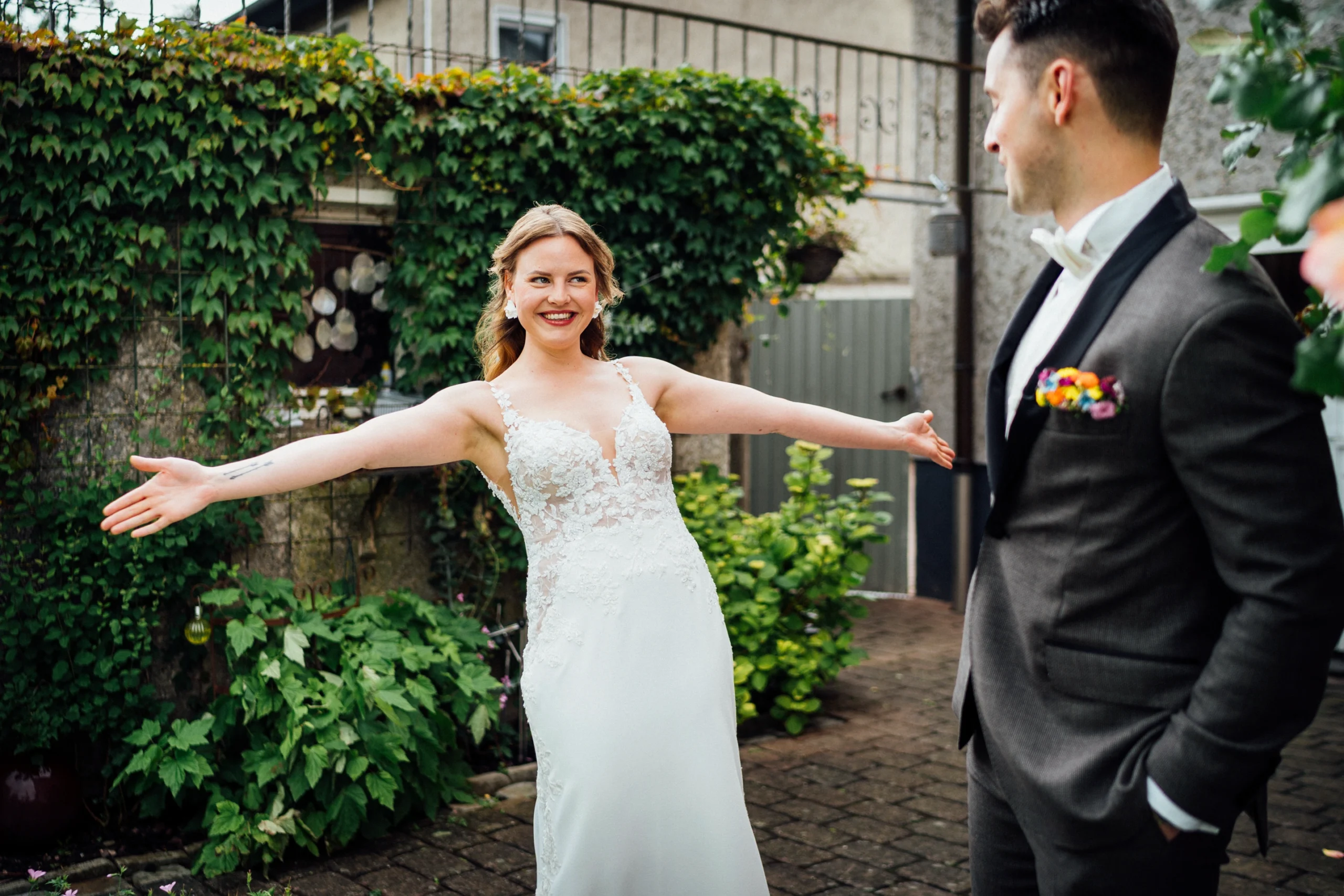 Braut und Bräutigam sehen sich beim First Look zum ersten Mal. Die Braut breitet ihre Arme aus