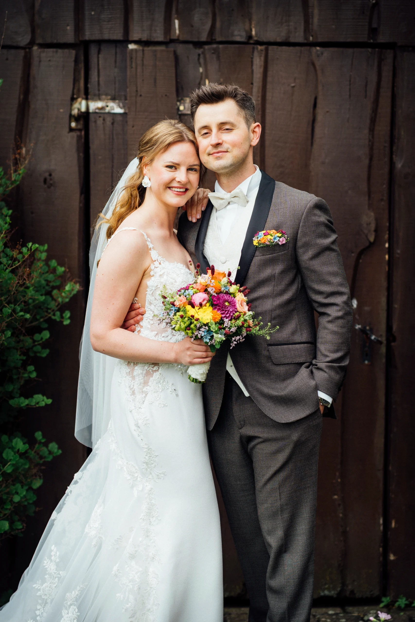 Ein Brautpaar posiert im Garten für ein erstes Foto