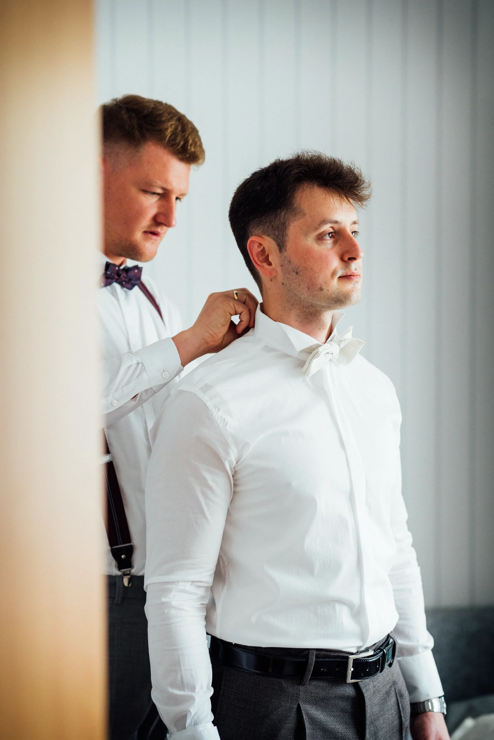 Der Trauzeuge richtet den Kragen beim Bräutigam