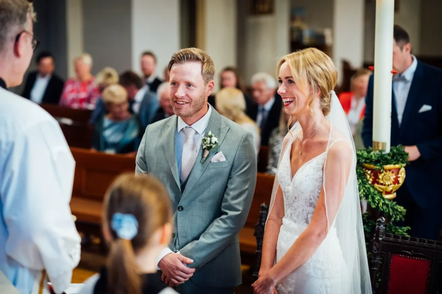 Braut und Bräutigam lachend vor der Trauung in der Kirche in Ostenland