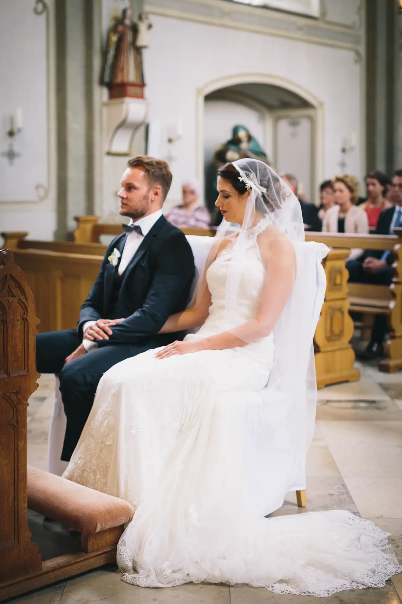 Brautpaar sitzt in der Kirche vor dem Altar