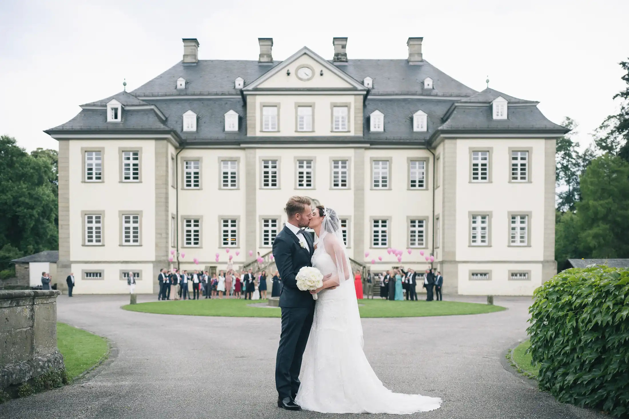 hochzeitsfotograf-schloss-koertlinghausen036 Brautpaar küsst sich vor Schloss Körtlinghausen