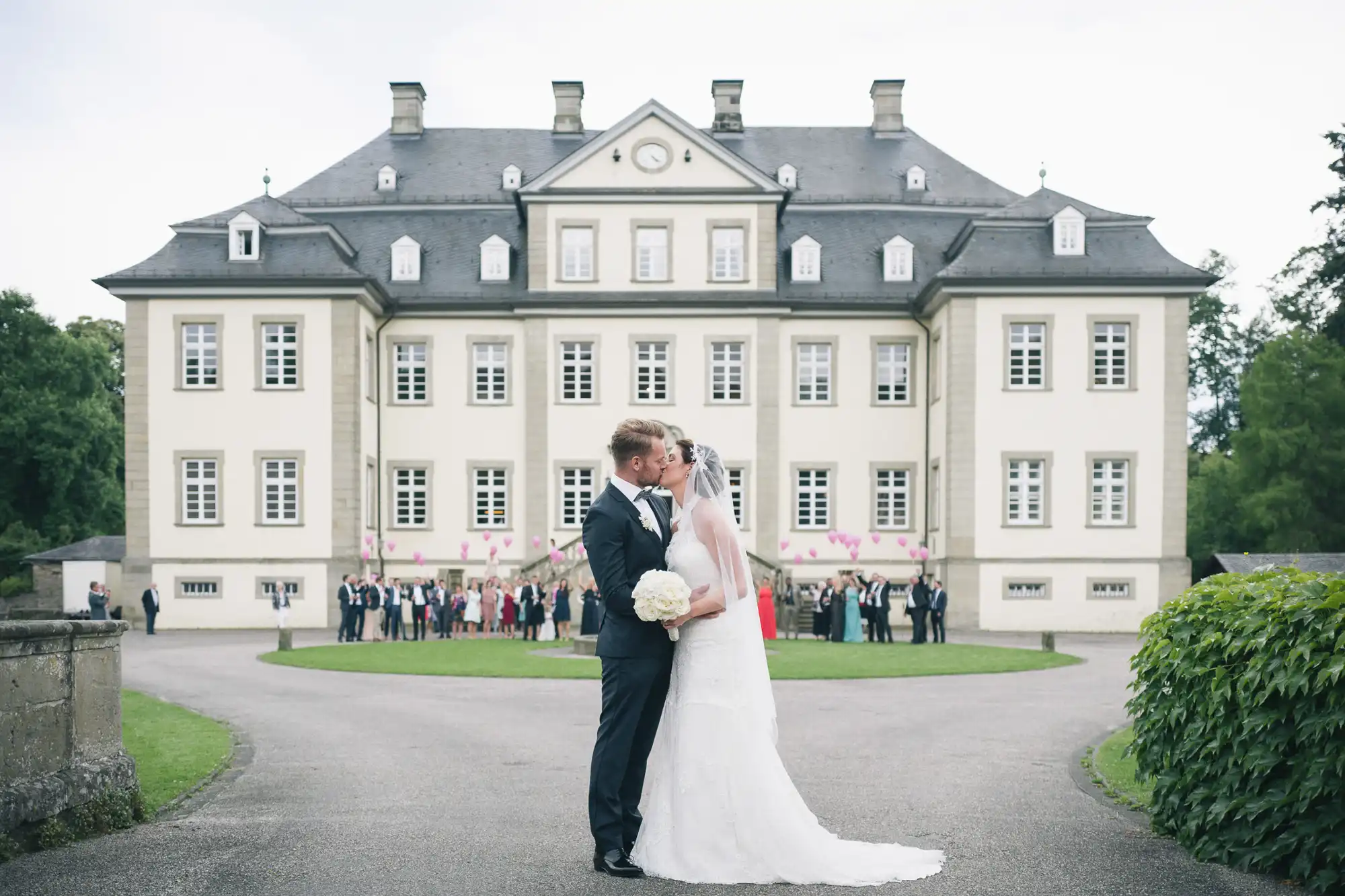 Brautpaar küsst sich vor Schloss Körtlinghausen
